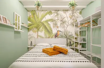 a bedroom with a bed with a tropical wallpaper at Vita lenta Roma Pigneto terrazza in Rome