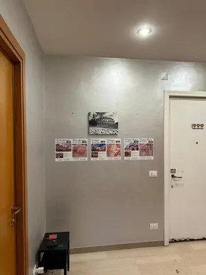 a wall with pictures and posters on it at Palm Rooms in Rome