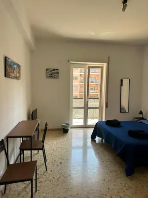a bedroom with a bed and a table and a window at Palm Rooms in Rome