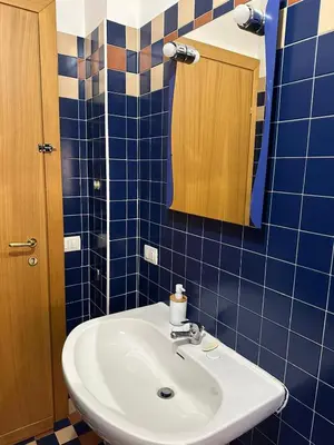 a bathroom with a sink and a mirror and blue tiles at Palm Rooms in Rome