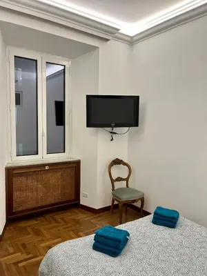 a bedroom with two beds and a flat screen tv at Domus Giovanna in Rome