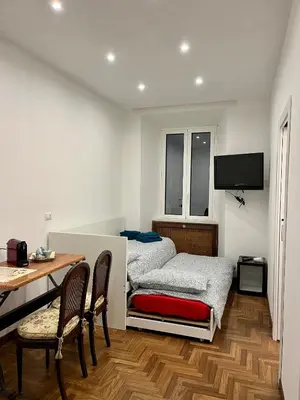 a room with two beds and a desk and a table at Domus Giovanna in Rome