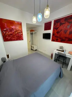 a bedroom with a bed and paintings on the walls at Mata Vatican Rooms in Rome