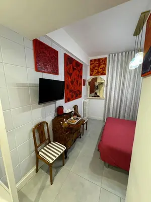 a living room with a red bed and a desk at Mata Vatican Rooms in Rome