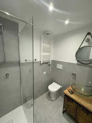 a bathroom with a toilet and a glass shower at Mata Vatican Rooms in Rome