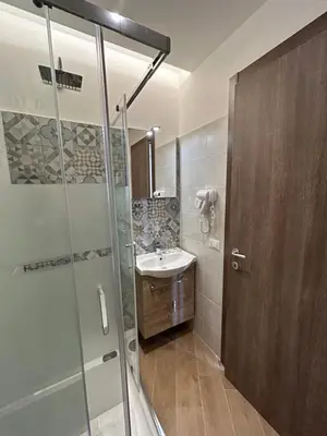 a bathroom with a glass shower and a sink at Grimaldi Comfort Guest House in Rome