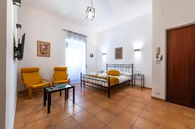 a bedroom with a bed and two chairs and a table at Gianicolense Apartment in Rome