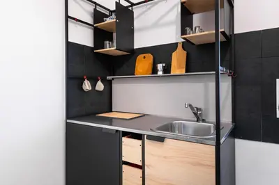 a small kitchen with a sink and shelves at Gianicolense Apartment in Rome