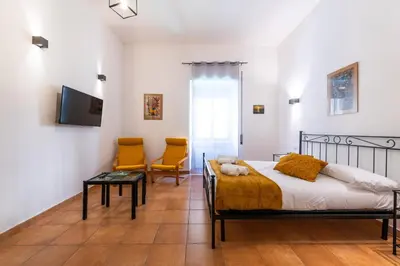 a bedroom with a bed and two chairs at Gianicolense Apartment in Rome