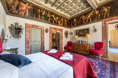a bedroom with a bed and a ceiling with paintings at Piazza Navona historical palace in Rome