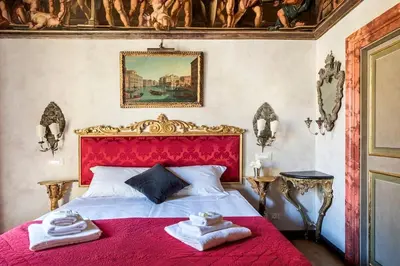 a bedroom with a red bed with towels on it at Piazza Navona historical palace in Rome