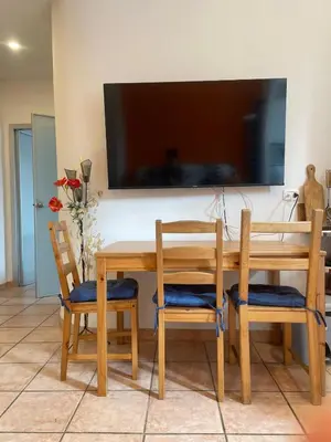 a wooden table with chairs and a television on a wall at Steph and Lorenzo's place in Rome