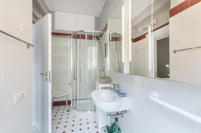 a white bathroom with a sink and a shower at La Terrazza di Vigna Clara in Rome