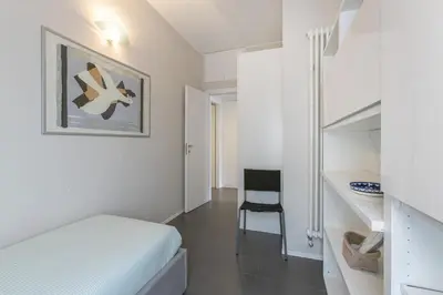 a white room with a bed and a chair at La Terrazza di Vigna Clara in Rome