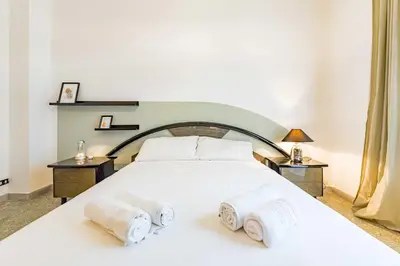 a bedroom with a white bed with towels on it at Iolanda Fine & Spacious Flat in Rome