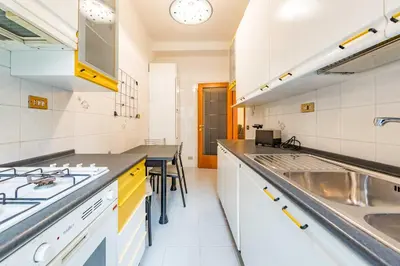 a kitchen with a black counter and a table at Iolanda Fine & Spacious Flat in Rome