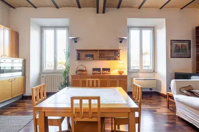 a dining room with a table and chairs in a room at New Trastevere Home: big, elegant, comfy apartment in Rome
