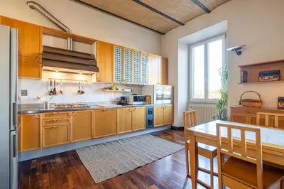 a large kitchen with wooden cabinets and a table at New Trastevere Home: big, elegant, comfy apartment in Rome