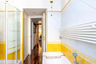 a bathroom with yellow and white walls and a tub at New Trastevere Home: big, elegant, comfy apartment in Rome