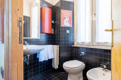 a bathroom with a toilet and a sink at New Trastevere Home: big, elegant, comfy apartment in Rome