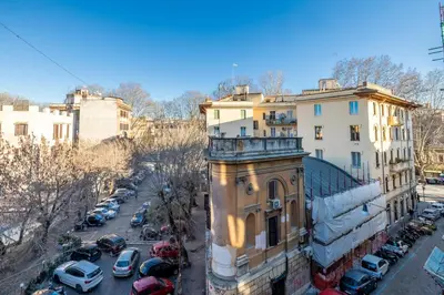 a building with cars parked in a parking lot at New Trastevere Home: big, elegant, comfy apartment in Rome