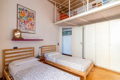 two beds in a room with white cabinets at New Trastevere Home: big, elegant, comfy apartment in Rome