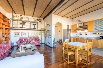 a kitchen and living room with a red couch and a table at New Trastevere Home: big, elegant, comfy apartment in Rome