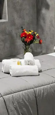 a bed with towels and a vase with flowers at Dolce Titina Affittacamere in Rome