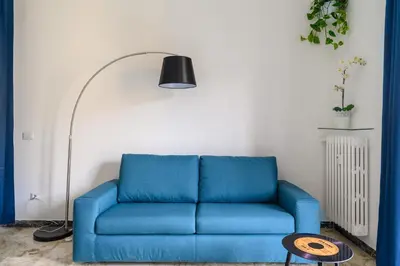 a blue couch in a living room with a lamp at Domus Vatican View - San Pietro in Rome