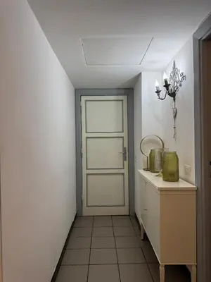 a hallway with a door and a tiled floor at Blancmaisonteveresuite in Rome