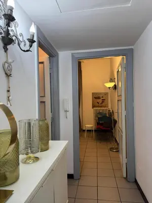 a kitchen with a hallway leading to a living room at Blancmaisonteveresuite in Rome