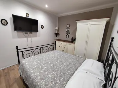 a bedroom with a bed and a flat screen tv at Appartamento Suite Ponte Milvio in Rome