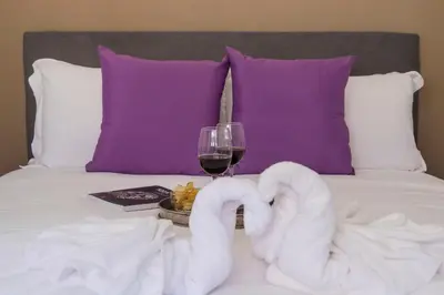 a bed with two swans with a glass of wine at New special vrbs Roma apartament in Rome