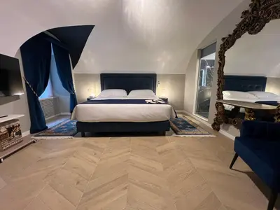a bedroom with a large bed and a blue couch at Rome luxury blue suites- IMPERIAL in Rome