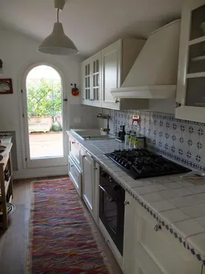 a kitchen with white cabinets and a stove top oven at Sales in Rome
