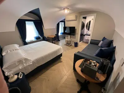 a bedroom with a large bed and a couch at Rome luxury blue suites- LOVE in Rome