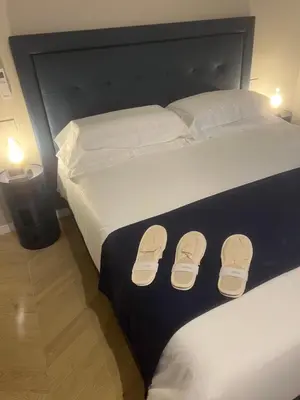 a bed with a pair of flip flops on it at Rome luxury blue suites- LOVE in Rome