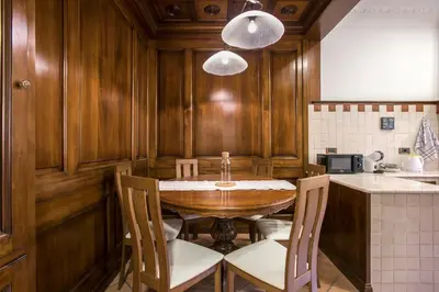 a kitchen with a wooden table and chairs at Appia Luxe - A poche fermate del Centro in Rome