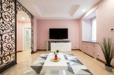 a living room with pink walls and a large mirror at Appia Luxe - A poche fermate del Centro in Rome