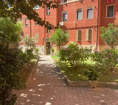 a walkway in front of a red brick building at Beatrice's House Spa Bath Privata e Parcheggio Gratuito a Roma in Rome