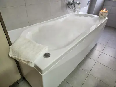 a white bath tub in a bathroom with a candle at Beatrice's House Spa Bath Privata e Parcheggio Gratuito a Roma in Rome