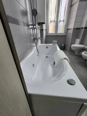 a white bath tub in a bathroom with a toilet at Beatrice's House Spa Bath Privata e Parcheggio Gratuito a Roma in Rome