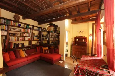 a living room with a red couch and book shelves at Bollo Studio in Rome
