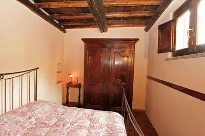 a bedroom with a bed and a wooden cabinet at Bollo Studio in Rome