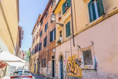 a building with graffiti on the side of a street at Sweet home Trastevere- Roma in Rome