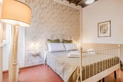 a bedroom with a white bed and a lamp at Sweet home Trastevere- Roma in Rome