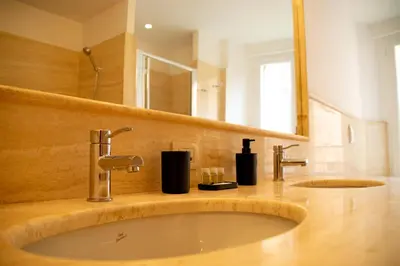 a bathroom with a sink and a mirror at Velabro Luxury Loft in Rome