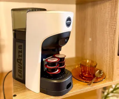 a coffee maker on a shelf next to a coffee pot at Velabro Luxury Loft in Rome
