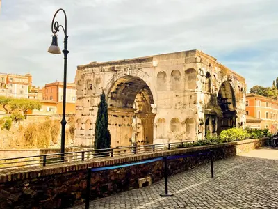 an old building with an arch in a city at Velabro Luxury Loft in Rome