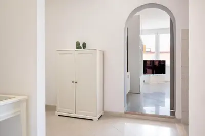 a white cabinet in a white room with a mirror at Roma per te in Rome